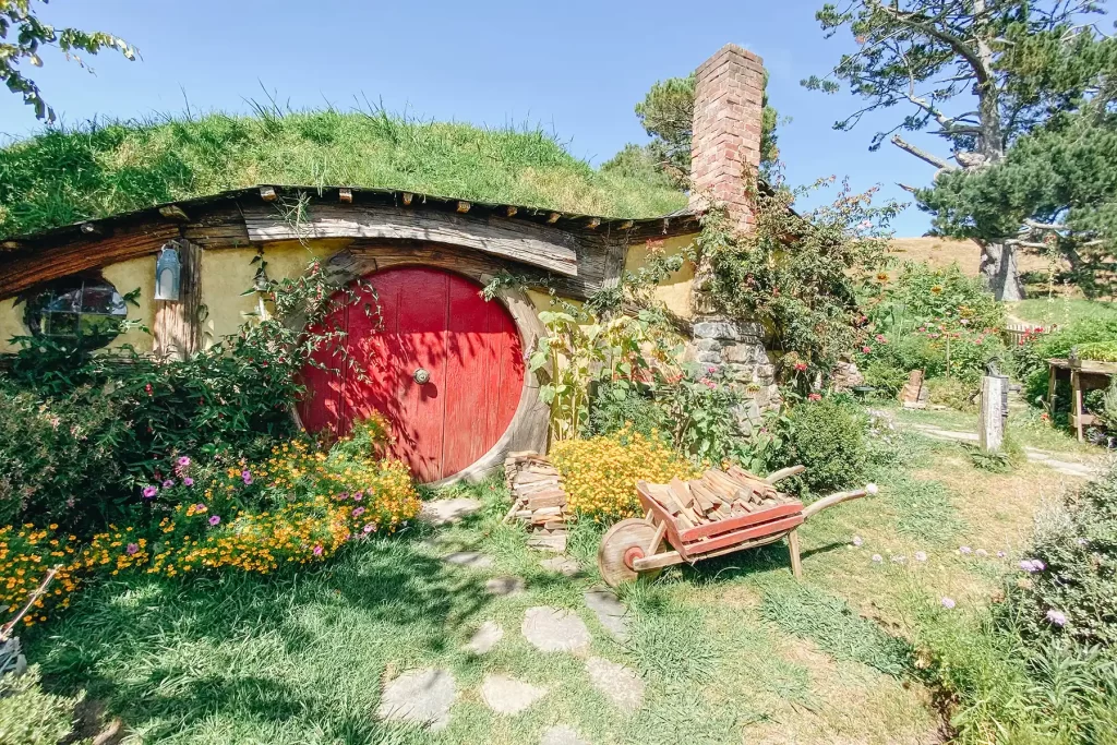 Hobbiton garden, wheelbarrow and red door.