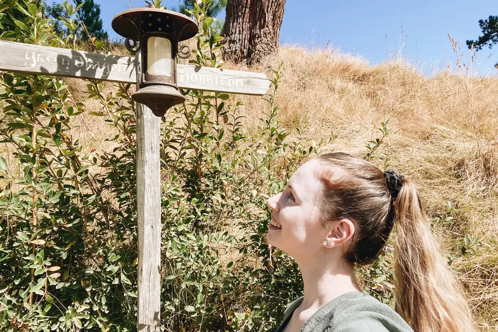Elle McFadzean looking at Hobbiton directions sign.