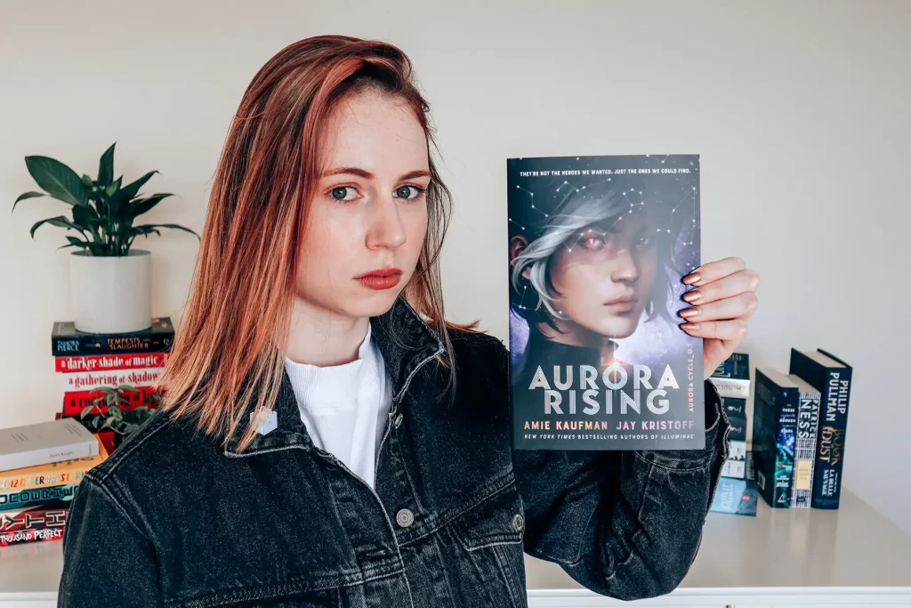 Elle McFadzean holding Aurora Rising book.