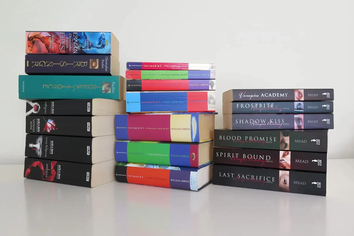 Three stacks of books that made me a reader, including Harry Potter, Vampire Academy, Twilight and Eragon.