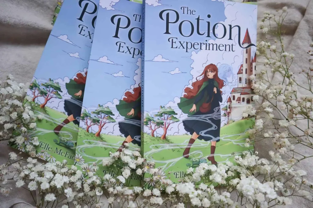A stack of The Potion Experiment books surrounded by flowers. My author inbox has been filled with spam about my book.